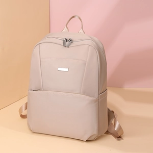 Detail view of large capacity beige leisure backpack with smooth nylon finish and metal zippers