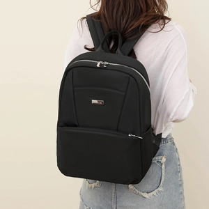Detail of minimalist black nylon backpack with durable metal zippers and padded straps