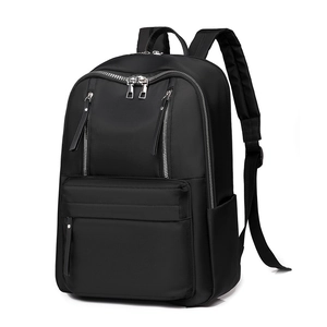 Detail view of black waterproof nylon backpack featuring dual vertical zipper pockets