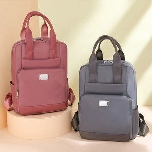 Vue détaillée de grands sacs à dos en nylon imperméable rouge et gris sur podiums
