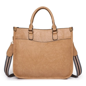 Détail du cabas vintage camel avec texture grainée et bandoulière tissée à rayures