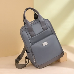 Détail d'un sac à dos gris imperméable avec poche frontale et porte-bouteille