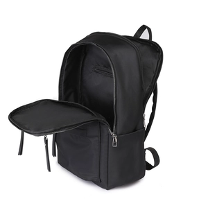 Detail of black nylon travel backpack showing interior compartments and silver zippers