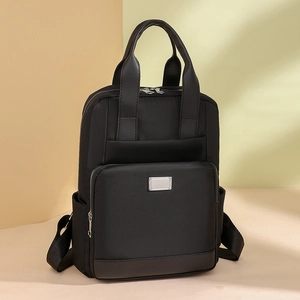 Détail du sac à dos noir en nylon avec poignées en cuir et poche zippée métallique