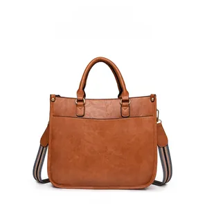 Gros plan du sac à main vintage marron avec texture litchi et sangle rayée