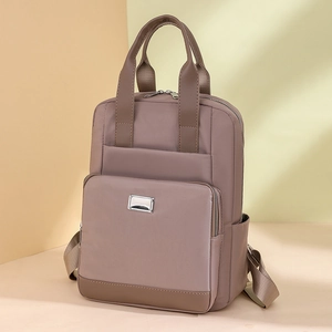 Détail du sac à dos polyvalent marron clair avec poignées renforcées et poche zippée
