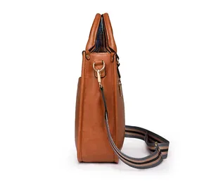 Vue latérale d'un sac à main marron avec bandoulière rayée et détails métalliques dorés