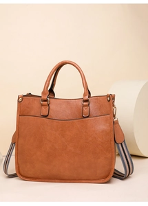 Détail du cabas en similicuir marron avec texture et bandoulière en tissu rayé coloré