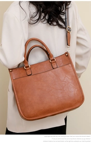 Vue détaillée d'un sac cabas en cuir marron avec une large bandoulière rayée