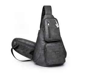 Détail d'un sac bandoulière en cuir gris foncé avec port pour écouteurs et poches zippées