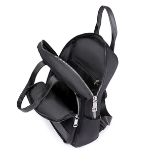 Vue détaillée du sac à dos en nylon noir montrant le compartiment intérieur et les zips