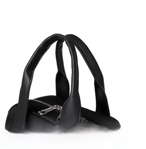 Détails macro du sac en nylon noir montrant les poignées en cuir et les fermetures éclair
