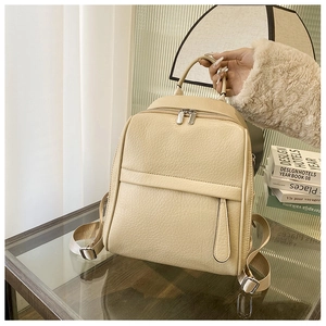 Détail d'un sac à dos blanc crème en cuir grainé avec fermetures éclair métalliques