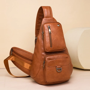 Detail view of the brown synthetic leather crossbody bag with multi-pocket design and metal D-ring