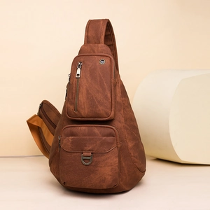 Detail view of multi-pocket dark brown crossbody bag with matte faux leather texture