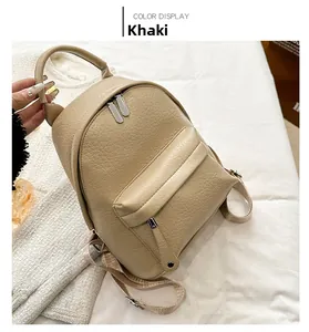 Detail view of khaki PU leather backpack with pebble texture and front zipper pocket