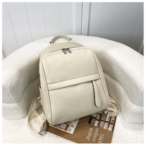 Détail du sac à dos en cuir grainé crème avec double fermeture éclair et poche latérale