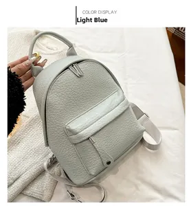 Close-up of light blue mini backpack in lychee texture PU leather with top handle