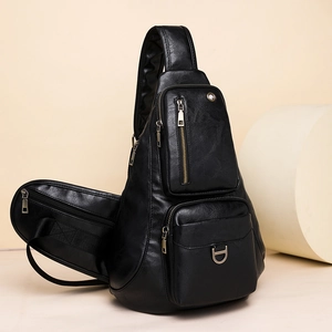 Detail view of black pebbled PU leather crossbody bag with multiple zipper compartments