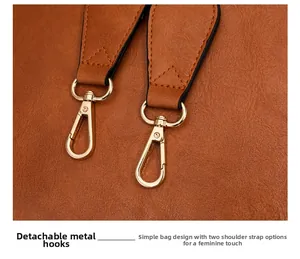 Détail du fermoir mousqueton en métal doré amovible sur un sac à main en cuir marron