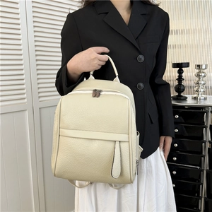 Gros plan du sac à dos en similicuir blanc crème avec grain de litchi et zip argenté