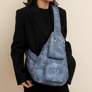 Detailed view of blue denim texture crossbody bag with multi-pocket functional design