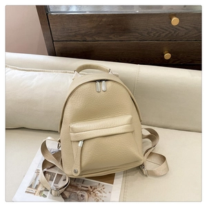 Detail of soft cream litchi grain PU leather backpack with silver metal zippers