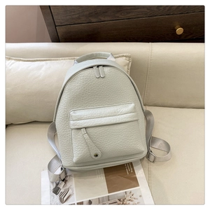 Detail of grey mini PU leather backpack showing lychee texture and silver metal zipper
