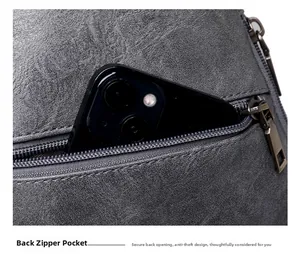 Détail de la poche zippée antivol à l'arrière d'un sac bandoulière gris foncé robuste