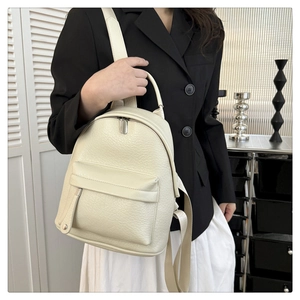 Close-up of cream soft PU leather backpack with pebble texture and adjustable straps