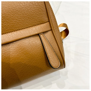 Détail de la texture cuir PU marron à motif litchi et languette de zip cousue