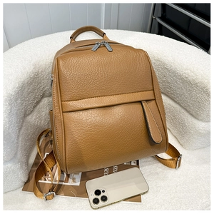 Détail d'un sac à dos marron en cuir PU à grain de litchi avec fermetures éclair argentées