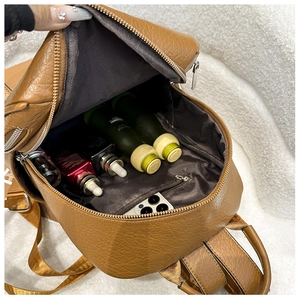 Détail de l'intérieur du sac à dos en cuir marron avec poche zippée et capacité de stockage