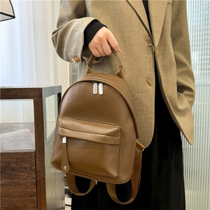 Close-up of vintage brown PU leather backpack with pebble texture and silver zippers