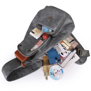 Gray cross-body bag detail showing spacious multi-pocket interior and high-capacity storage