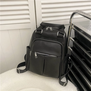 Side view of black litchi pattern leather backpack with silver zippers and side pockets