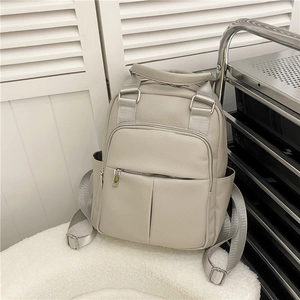 Detail of grey PU leather backpack featuring lychee texture and silver hardware zippers