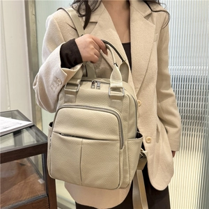Detail of off-white lychee grain leather backpack with dual zippers and side pockets