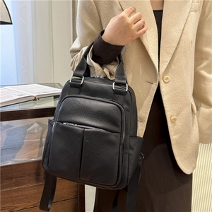Close-up of black PU leather backpack featuring litchi texture and silver hardware details