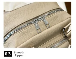 Detail view of the smooth dual silver zippers and lychee grain texture on the cream PU backpack