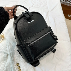 Detail shot of black pebble grain PU leather backpack with silver metal accent