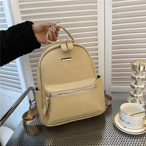 Detail of light beige lychee textured PU leather backpack with silver zippers