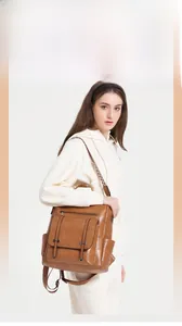 Detailed view of brown PU leather backpack featuring retro hardware and woven straps