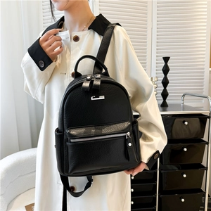 Close-up of black PU leather backpack featuring litchi texture and silver hardware details