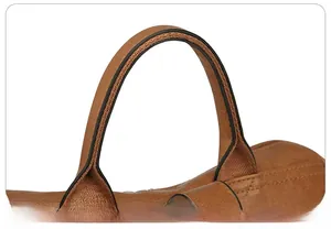 Close-up detail of reinforced brown leather handles with double stitching on backpack