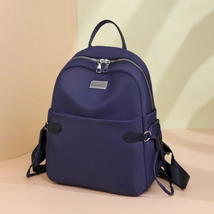 Detail eines dunkelblauen Oxford-Rucksacks mit Silberreißverschluss und Tragegurten