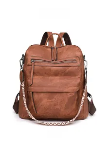 Detailed front view of brown PU leather backpack with decorative geometric strap