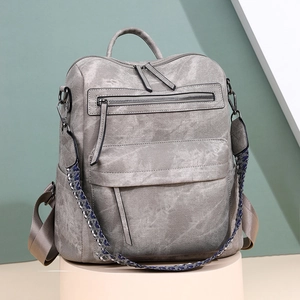 Détail d'un sac à dos en cuir PU gris avec texture vintage et sangle ethnique bleue