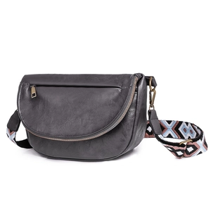 Detailed view of semi-circle faux leather bag with vintage metal zip and jacquard strap
