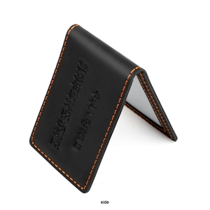 Macro detail of vintage black leather driver license holder with orange contrast stitching